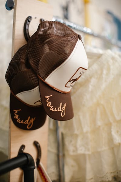 Embroidered caps hung on horseshoe hooks